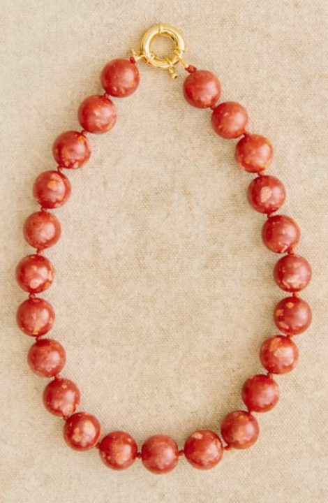 Un collier en perle rouge brique de chez Sezane