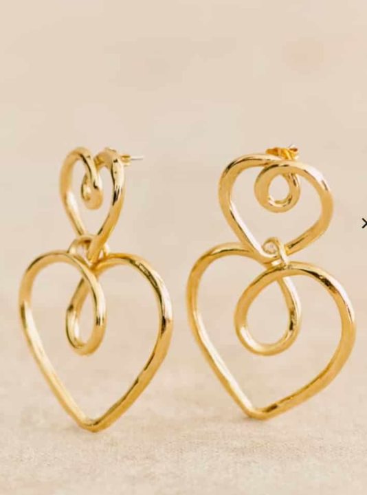Idée cadeau femme : une paire de boucles d'oreilles dorées en forme de coeur chez Sezane