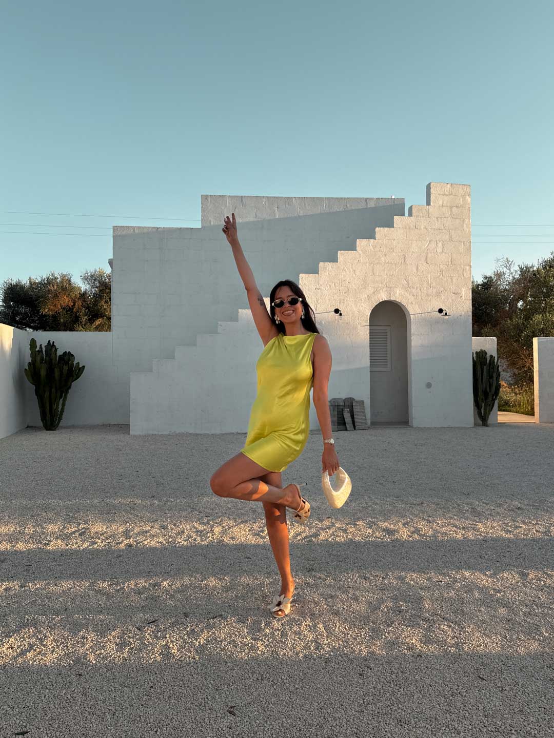 tenue de soirée été femme : robe courte satinée verte avec sac blanc nacré et sandales à fleurs