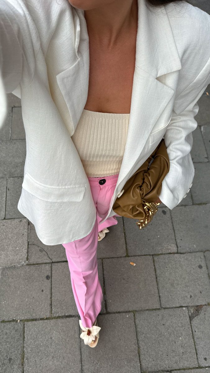 tenue chic bureau femme : pantalon rose, top crème et blazer en lin blanc