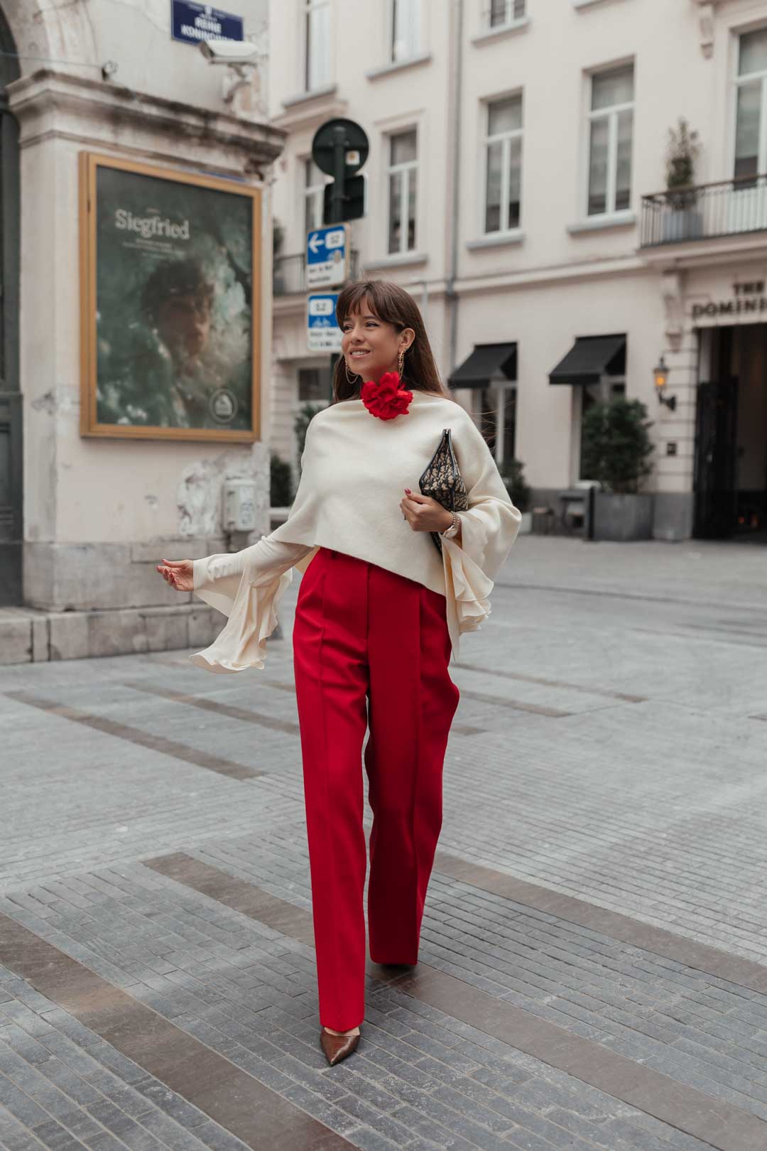 tenue élégante femme : pantalon rouge avec chemise beige et cape blanche