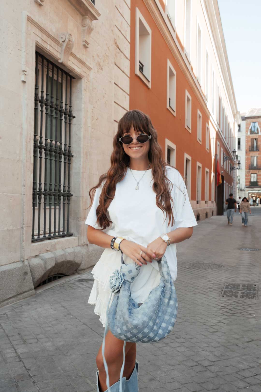 tenue festival femme : short beige avec t-shirt blanc, santiags et sac bleus