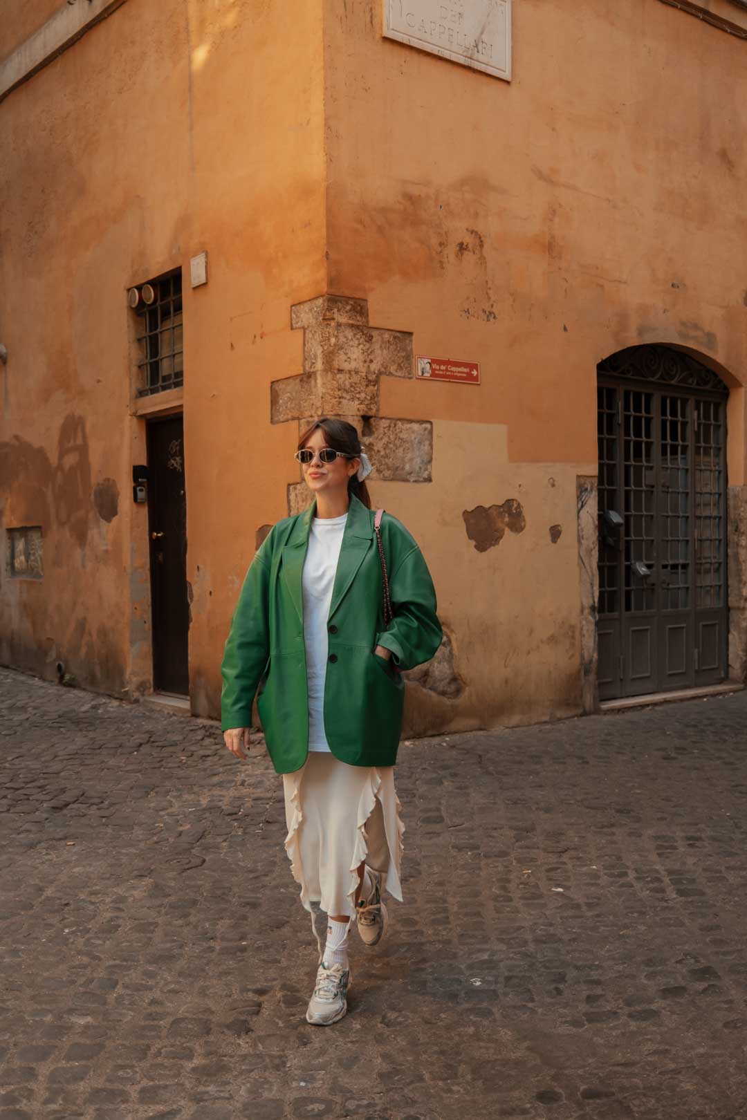 tenue femme à Rome : jupe longue beige Acne Studios, t-shirt blanc American Vintage, blazer en cuir vert Katso Cuir, sac rose Chanel, baskets Asics 