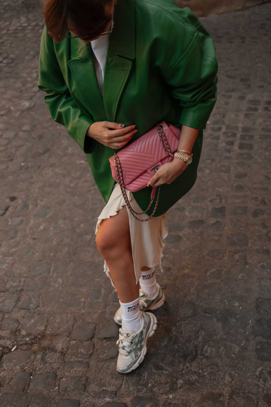 tenue femme à Rome : jupe longue beige Acne Studios, t-shirt blanc American Vintage, blazer en cuir vert Katso Cuir, sac rose Chanel, baskets Asics 