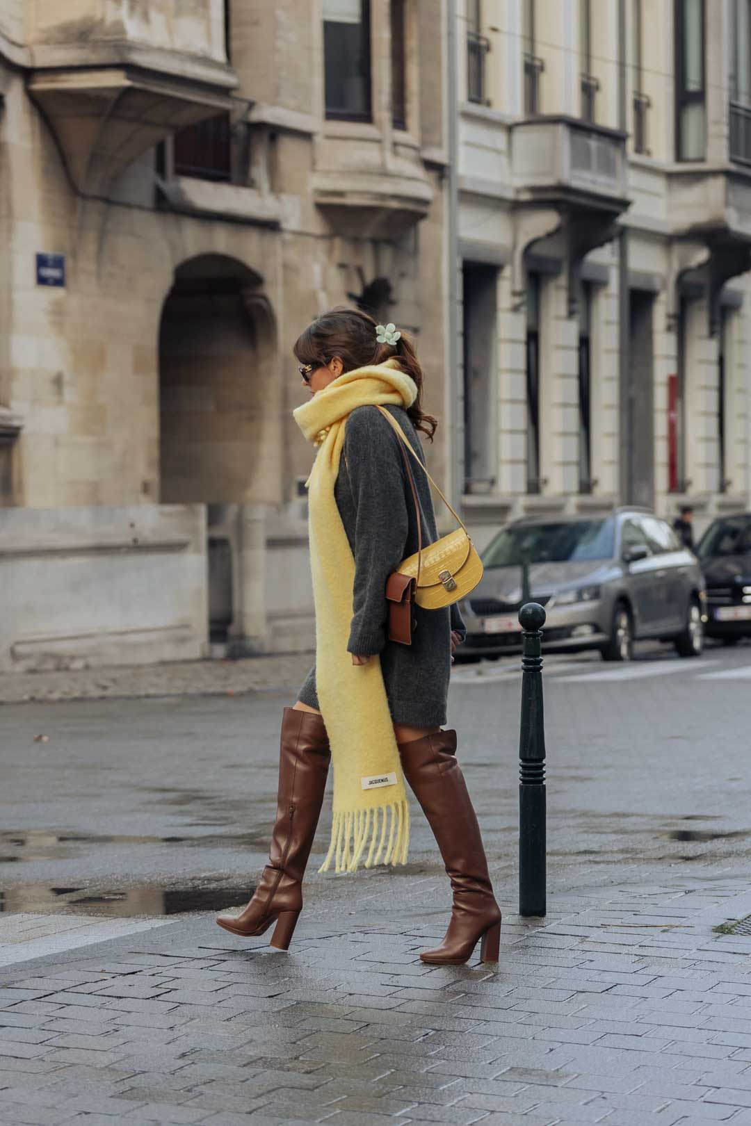 tenue femme Sézane avec robe pull grise, bottes marrons, sac jaune, écharpe jaune Jacquemus, lunettes de soleil Céline